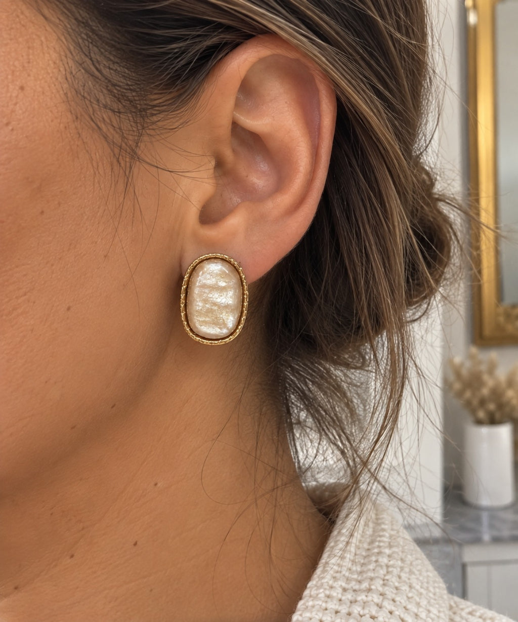 Boucle d’oreille ovale blanche nacrée en acier inoxydable portée à l’oreille