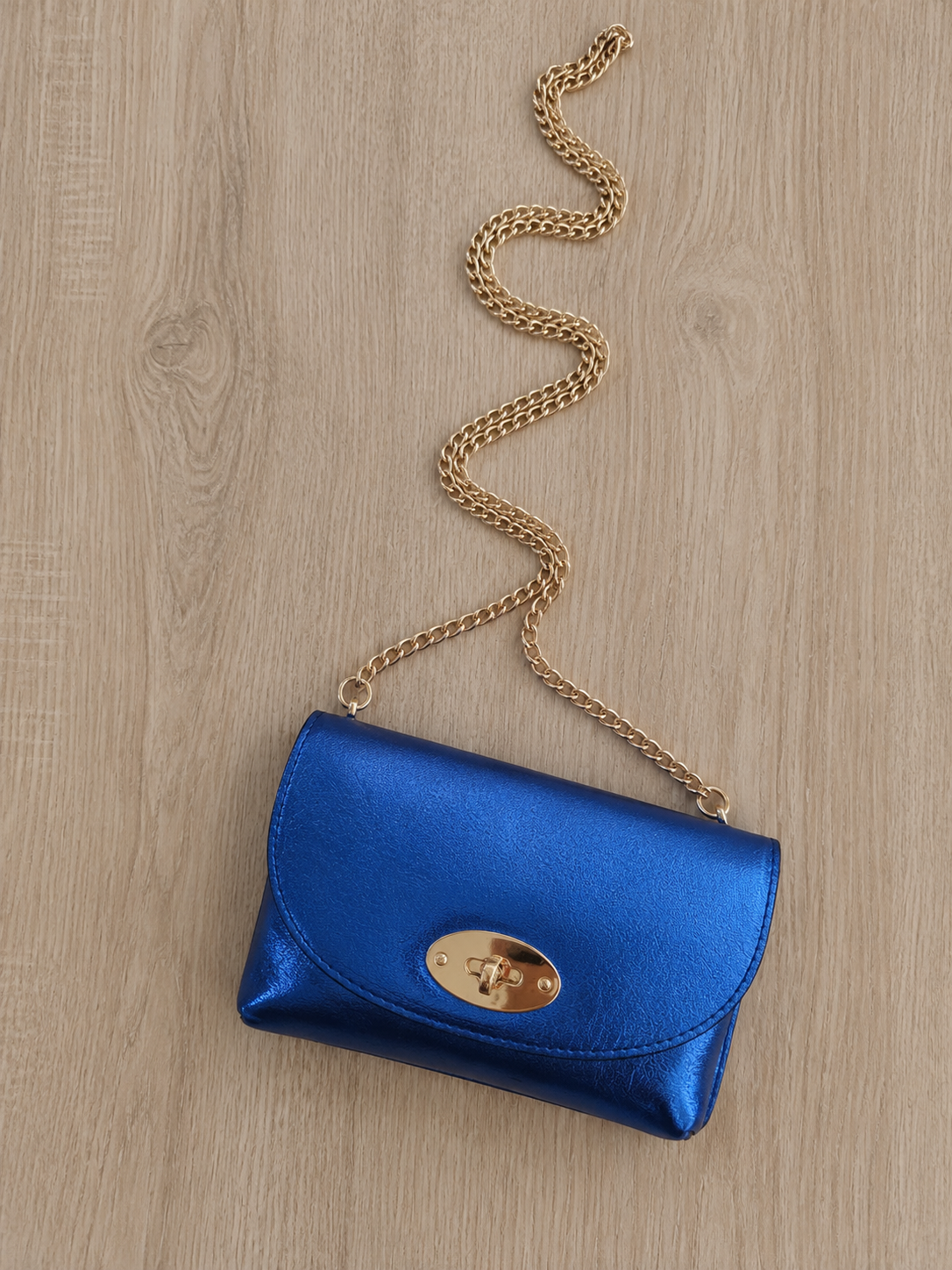 Sac bandoulière en cuir métallisé pour femme avec chaîne dorée, modèle Positano 18 × 11 cm, disponible en plusieurs coloris.