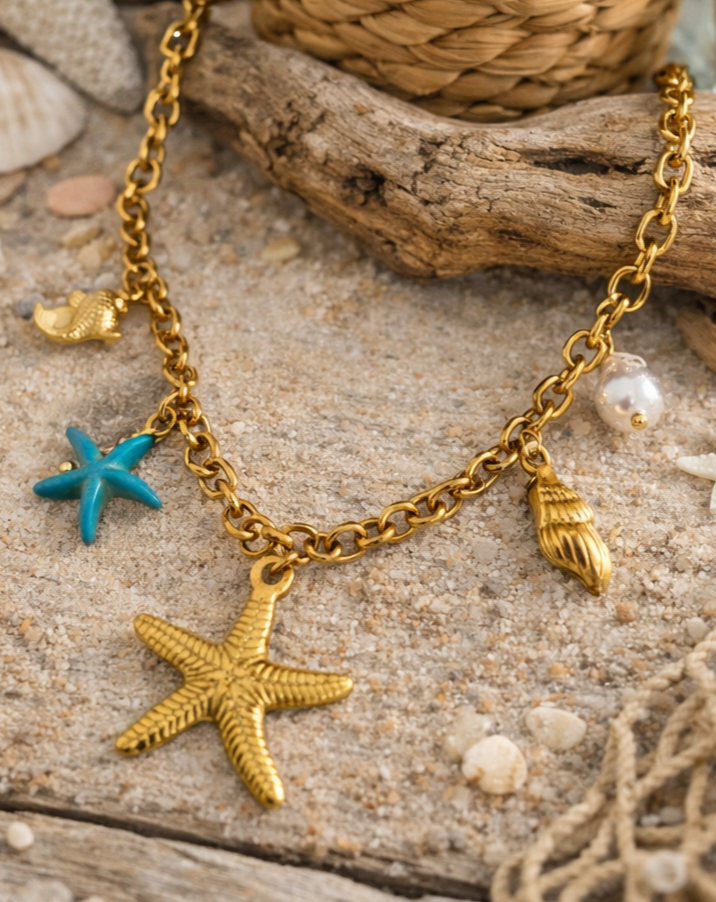 Collier acier inoxydable doré femme avec charms coquillages, étoile de mer, perle et étoile turquoise.
