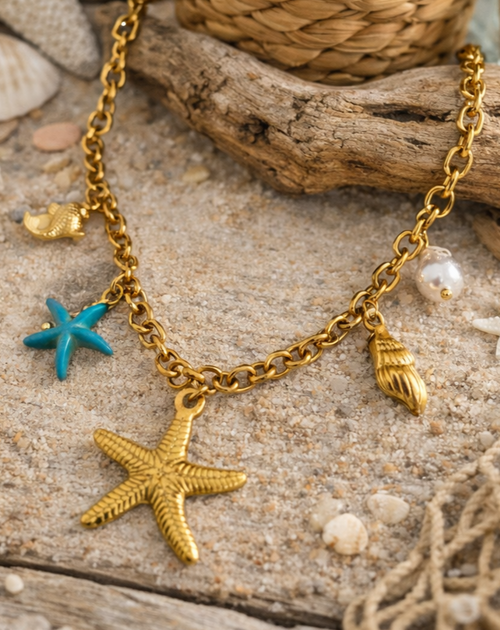 Collier acier inoxydable doré femme avec charms coquillages, étoile de mer, perle et étoile turquoise.