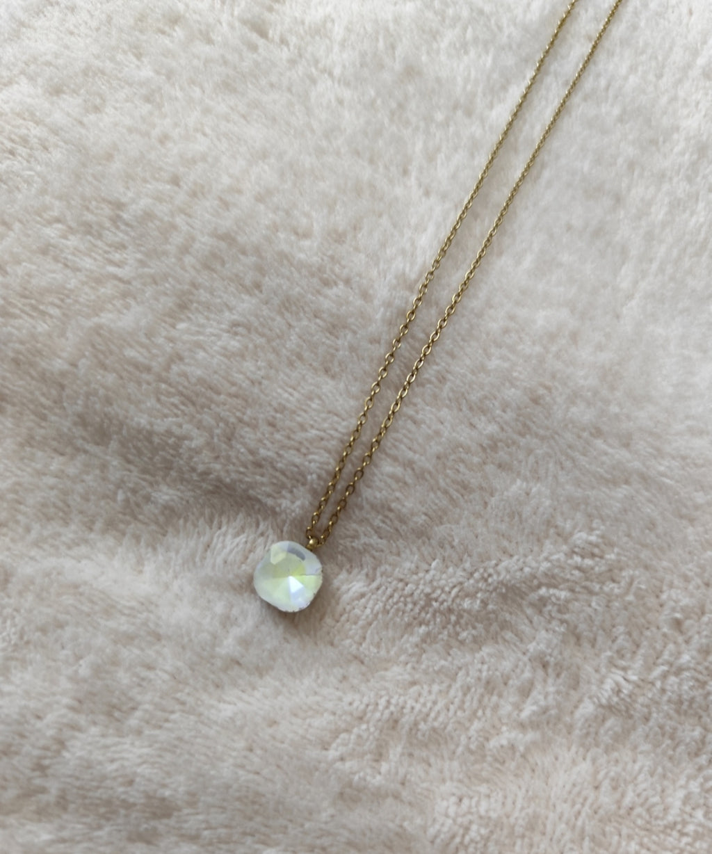 Collier Nerja en acier inoxydable doré avec pendentif en pierre facettée colorée blanc disponible en plusieurs coloris.