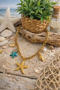 Collier acier inoxydable doré femme avec charms coquillages, étoile de mer, perle et étoile turquoise.