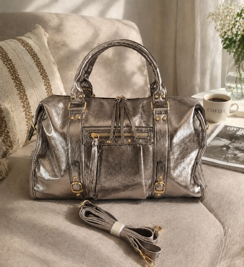 Sac de voyage en cuir métallisé doré avec finitions dorées, design structuré et bandoulière assortie