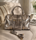 Sac de voyage en cuir métallisé doré avec finitions dorées, design structuré et bandoulière assortie
