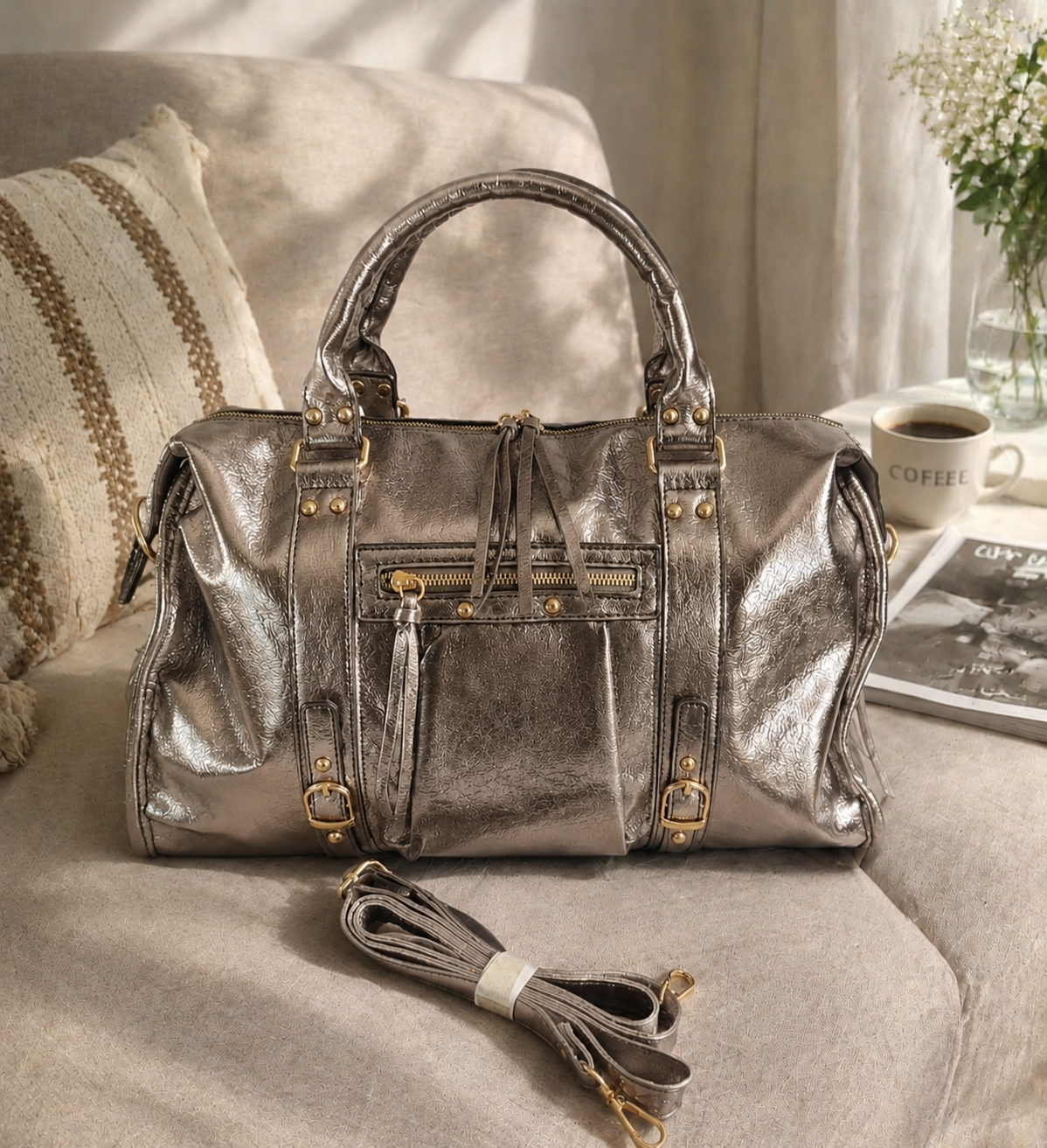 Sac de voyage en cuir métallisé doré avec finitions dorées, design structuré et bandoulière assortie