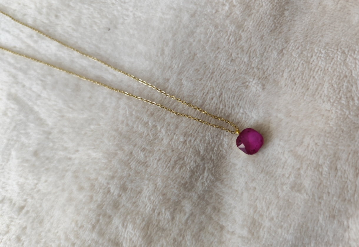 Collier Nerja en acier inoxydable doré avec pendentif en pierre facettée colorée fushia disponible en plusieurs coloris.