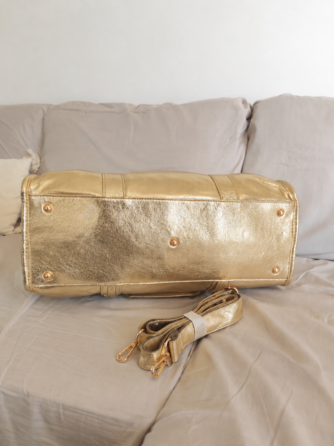 Sac de cours ou de voyage en cuir métallisé doré, style duffle bag, avec bandoulière amovible et finitions dorées, design élégant et spacieux