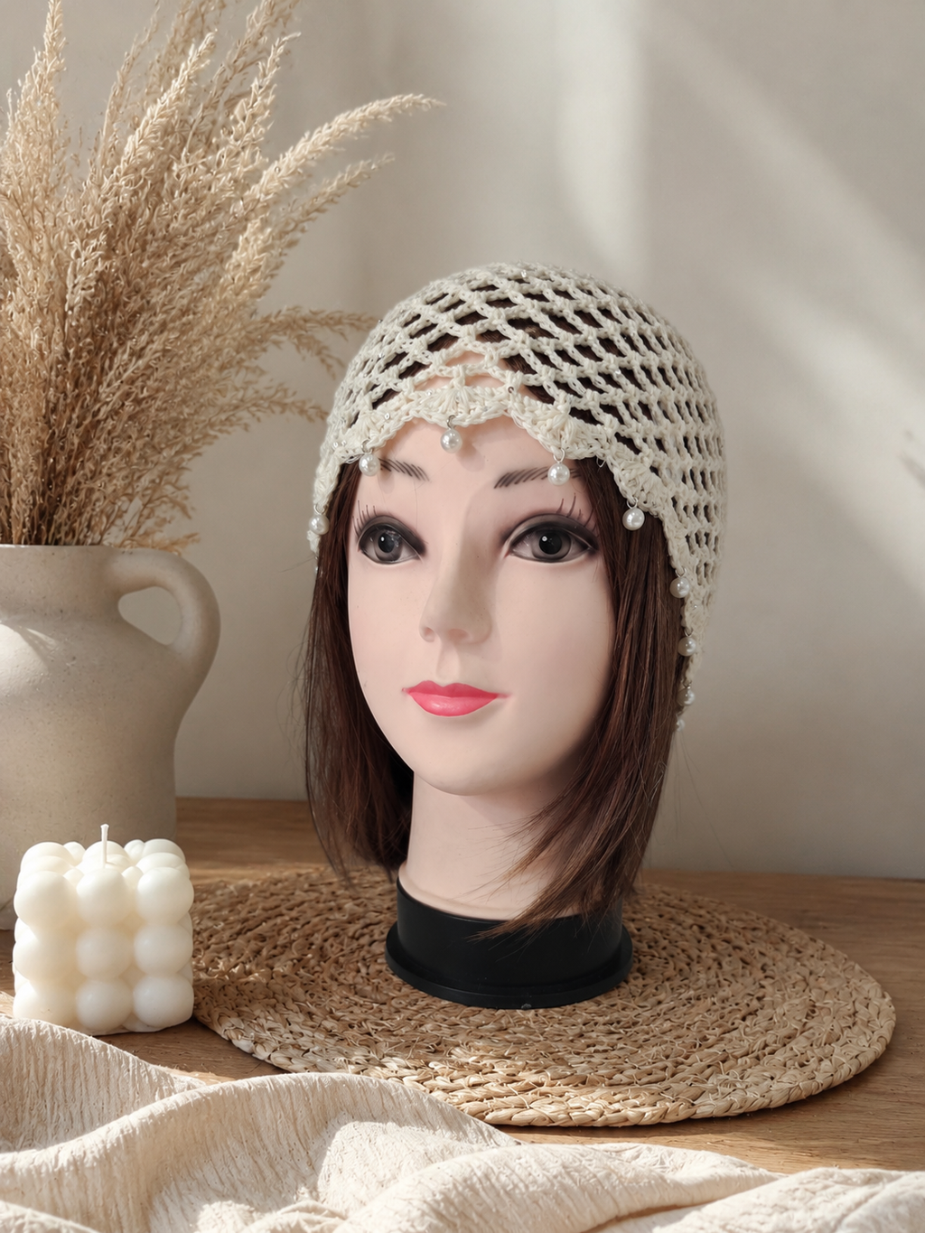 Bonnet en crochet blanc avec perles porté sur un mannequin, style bohème chic.