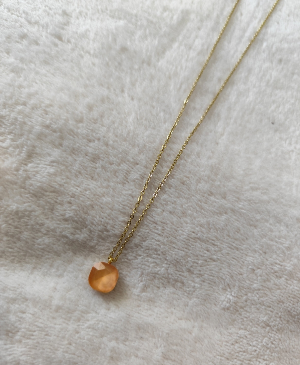 Collier Nerja en acier inoxydable doré avec pendentif en pierre facettée colorée orange disponible en plusieurs coloris.