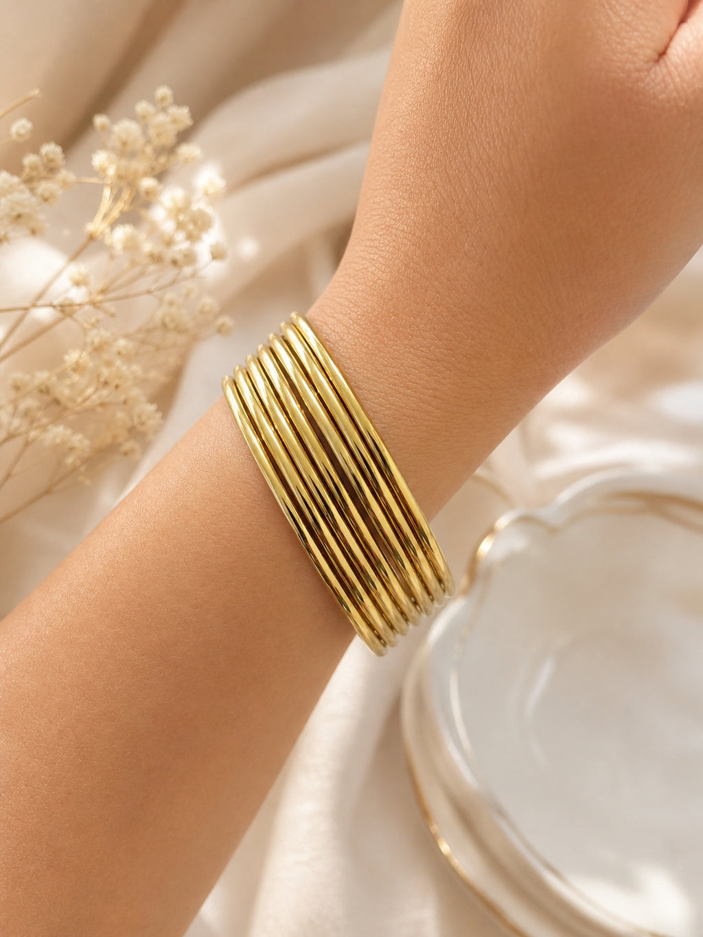 Semainier doré 7 bracelets joncs fins en acier inoxydable sur tissu clair